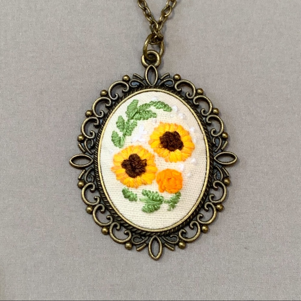 Hand embroidered sunflower pendant necklace.